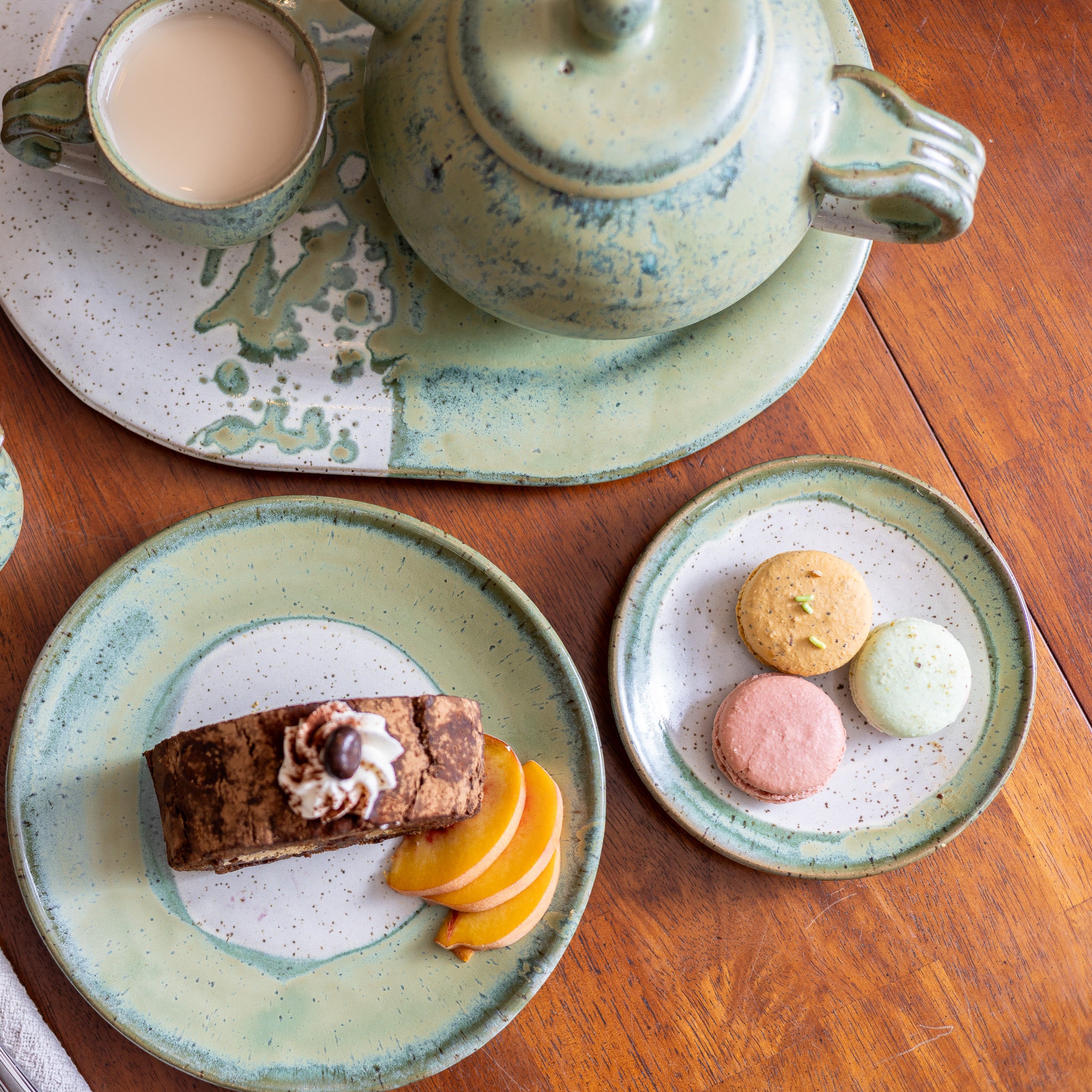 Six-piece dinnerware set glazed in Lillian glaze with a soft ivory surface and sage-tinted rim.
